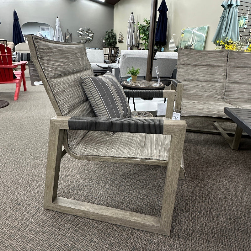 Outdoor furniture set including a chair and sofa on a carpeted floor.