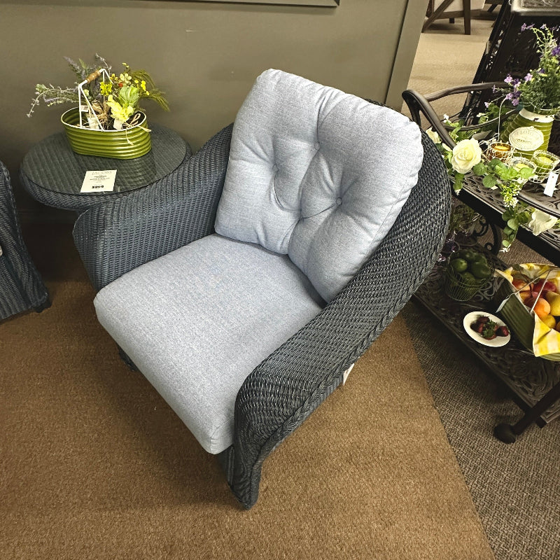 Gray wicker chair with gray cushions in a store setting