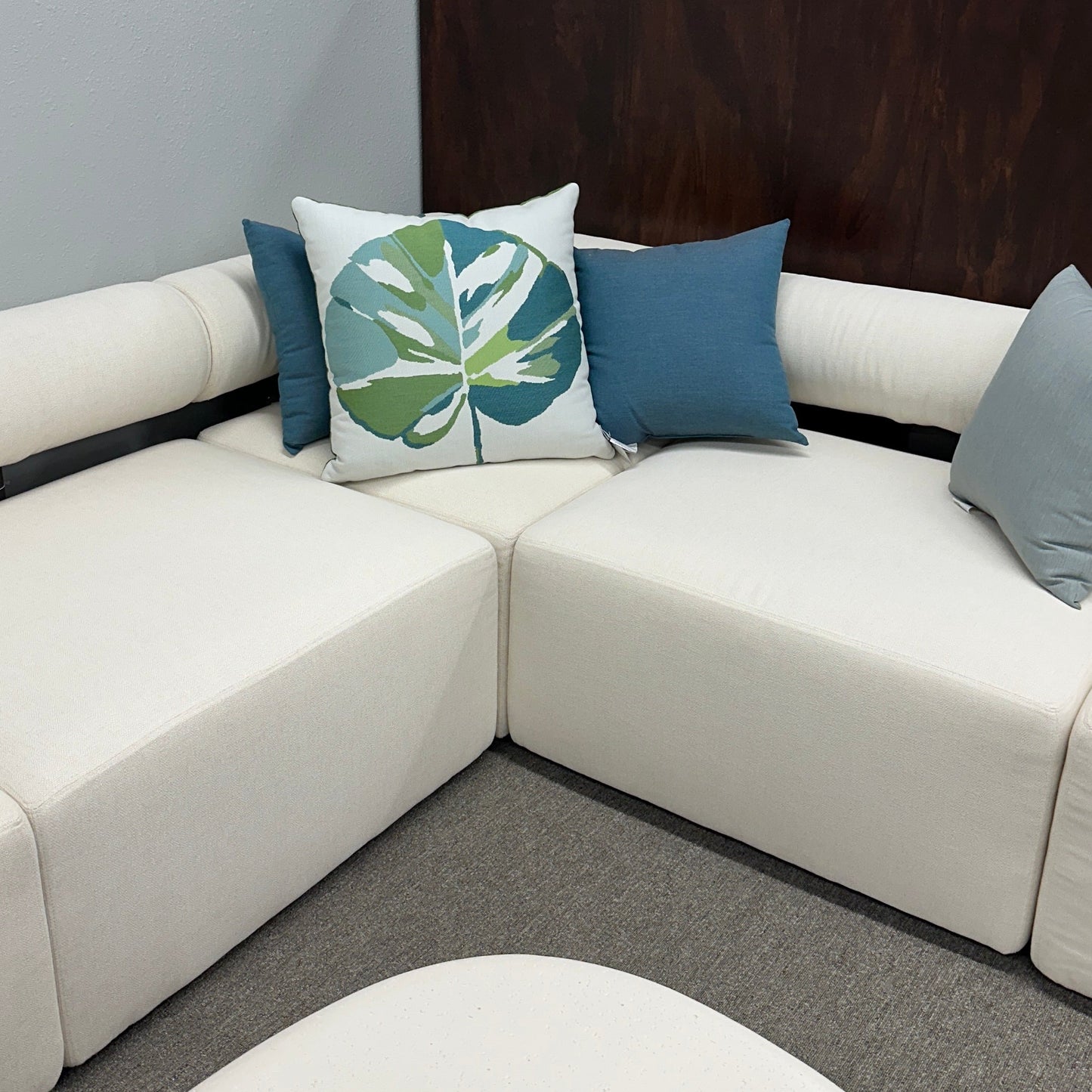White sectional sofa with decorative pillows in a living room setting.