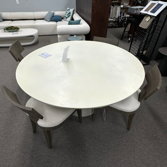 Modern dining area with a round white table and chairs in a room setting.