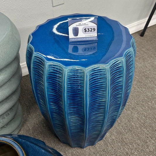 Blue ceramic stool with a price tag in a room setting