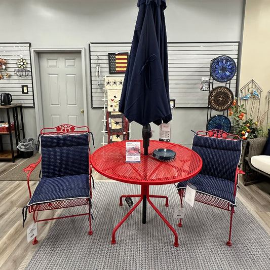 Outdoor furniture set with red table and blue chairs in a showroom.