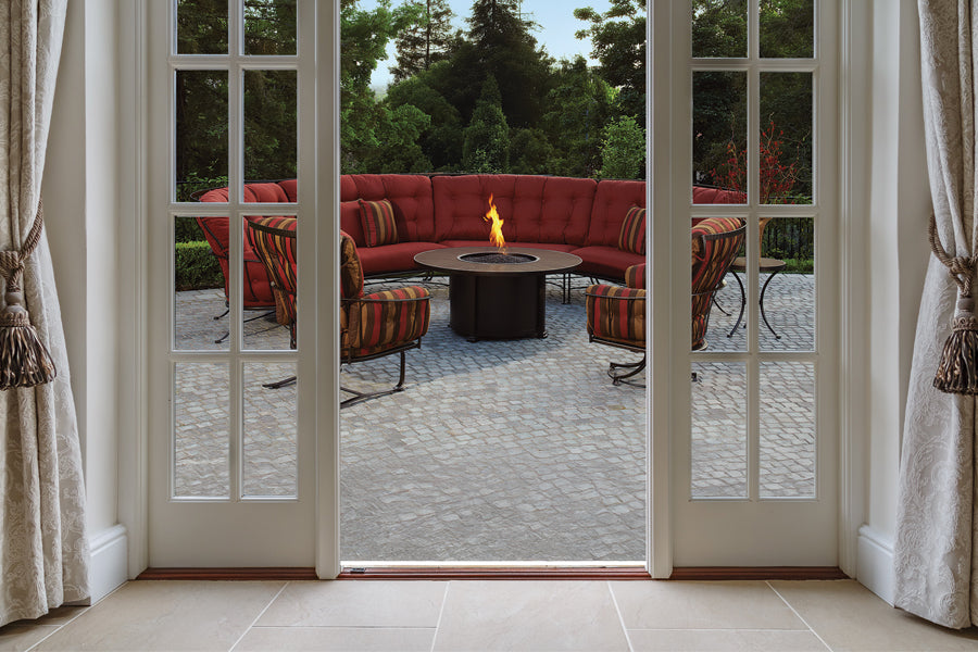 white french doors opened to ow lee maroon patio sectional and striped cushion patio chairs