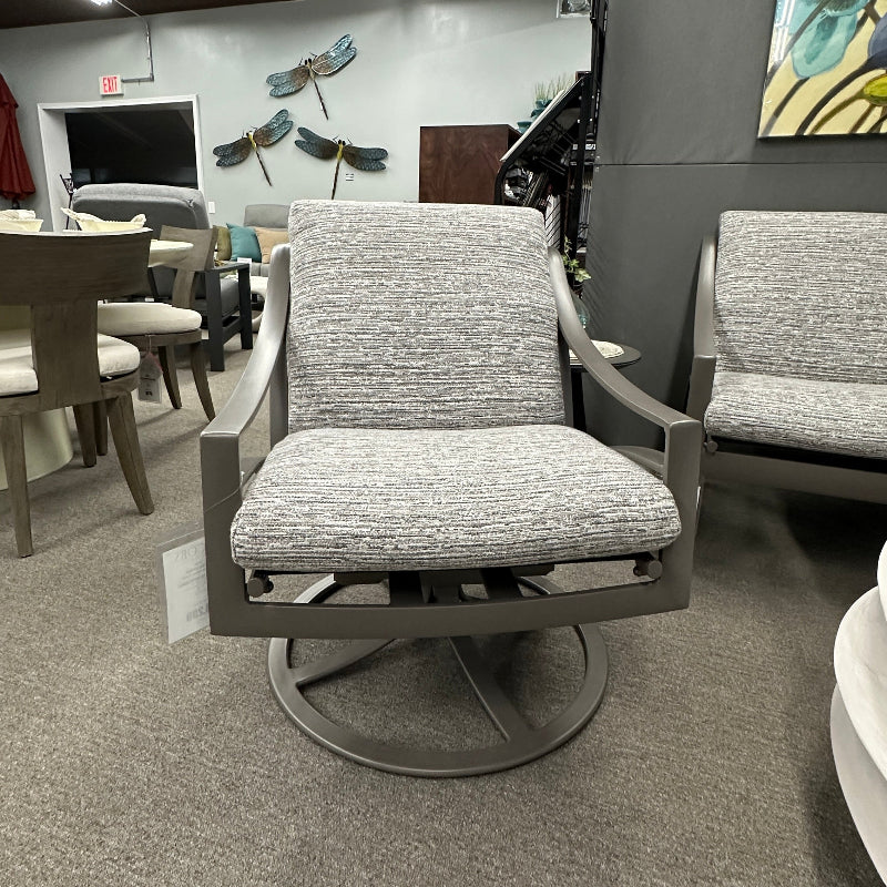 Gray swivel chair in a room with a painting on the wall