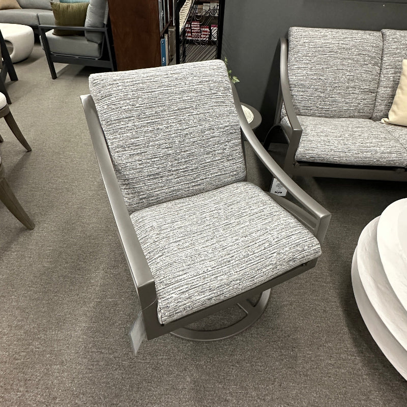 Gray upholstered chair in a room with other furniture and decor