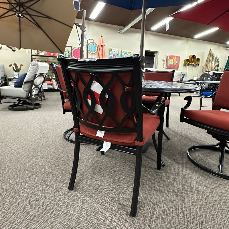 Outdoor furniture set with red chairs and a blue umbrella on a gray carpeted floor.