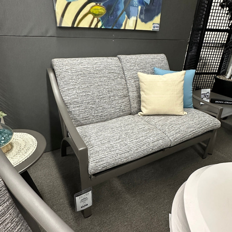 Gray sofa with cushions in a room with a painting on the wall.