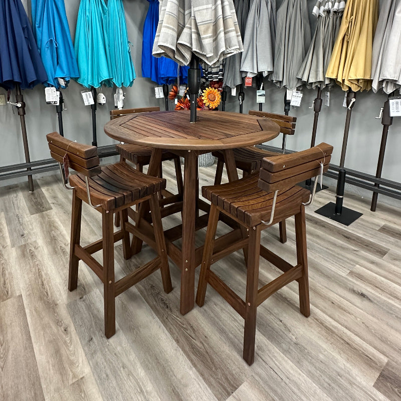 A 5-piece outdoor bar set consisting of a round wooden table and four matching wooden stools, displayed in a showroom with other patio umbrellas in the background.