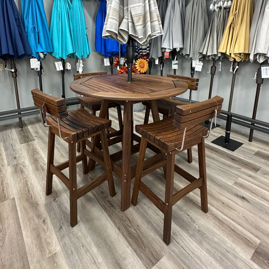 A 5-piece outdoor bar set consisting of a round wooden table and four matching wooden stools, displayed in a showroom with other patio umbrellas in the background.