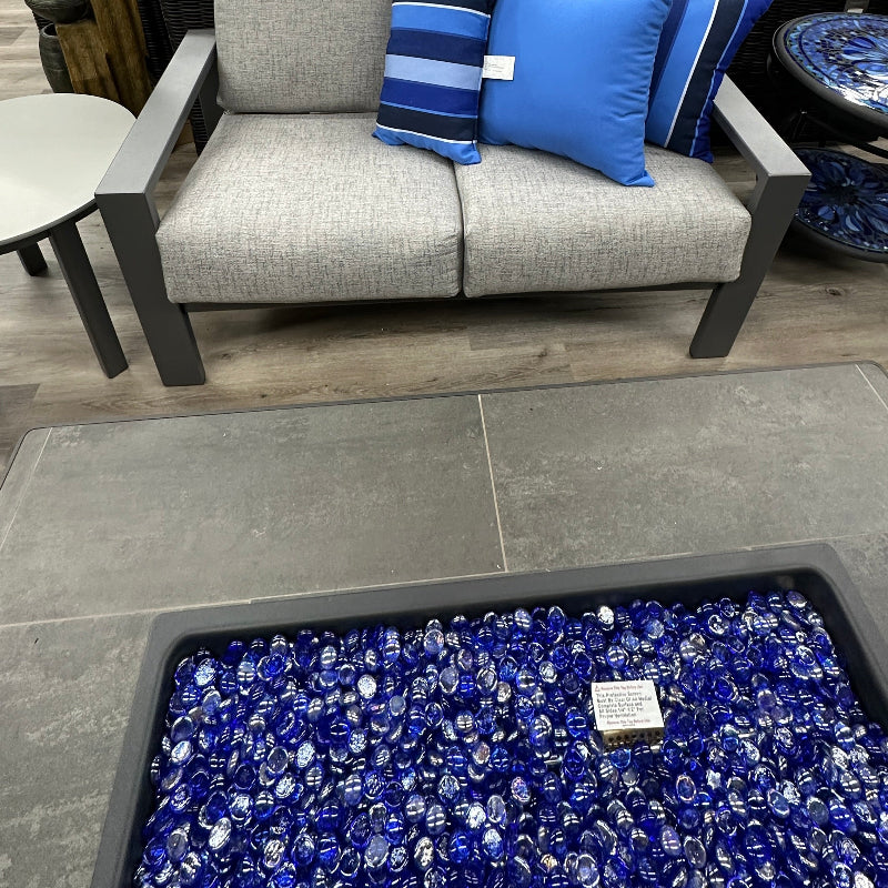 Gray sofa with blue and striped pillows in a furniture store setting