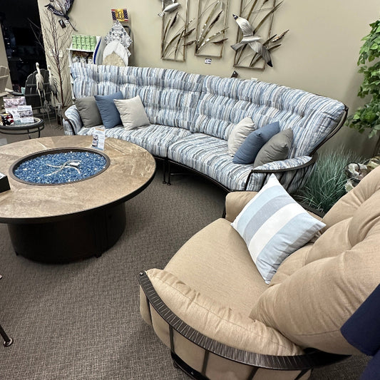 Living room with a curved sectional sofa, coffee table, and decorative elements.