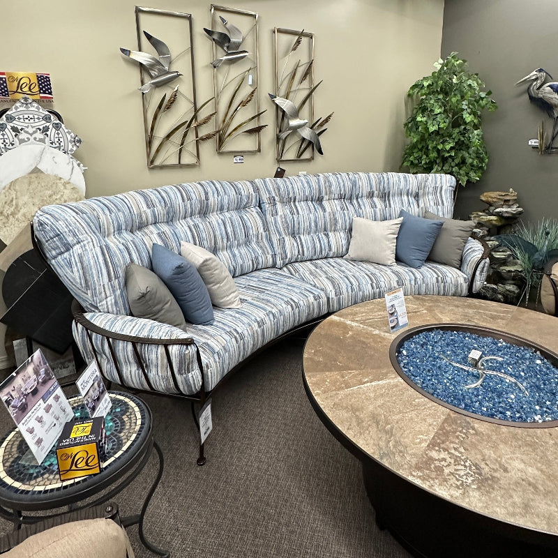 Living room with a curved sofa, coffee table, and decorative elements.