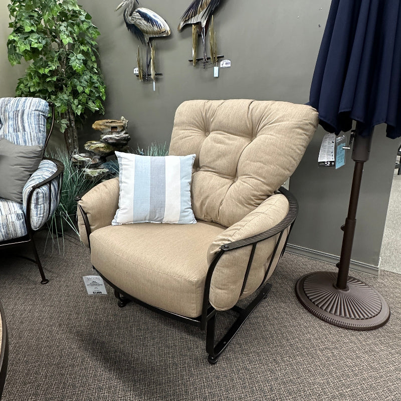 Beige armchair with a striped pillow in a room setting with decorative elements.