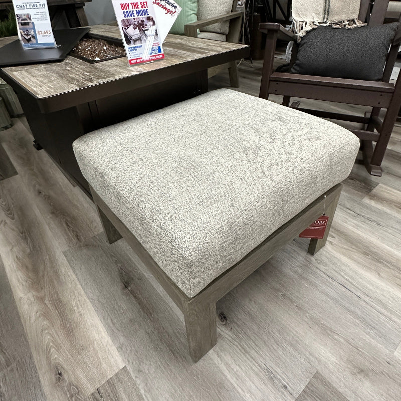 Outdoor furniture set with a cushioned ottoman on a wooden floor.