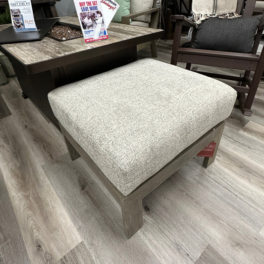 Outdoor furniture set with a cushioned ottoman on a wooden floor.