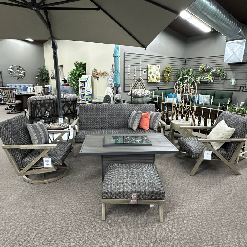 Outdoor furniture set with tables and chairs in a showroom setting.