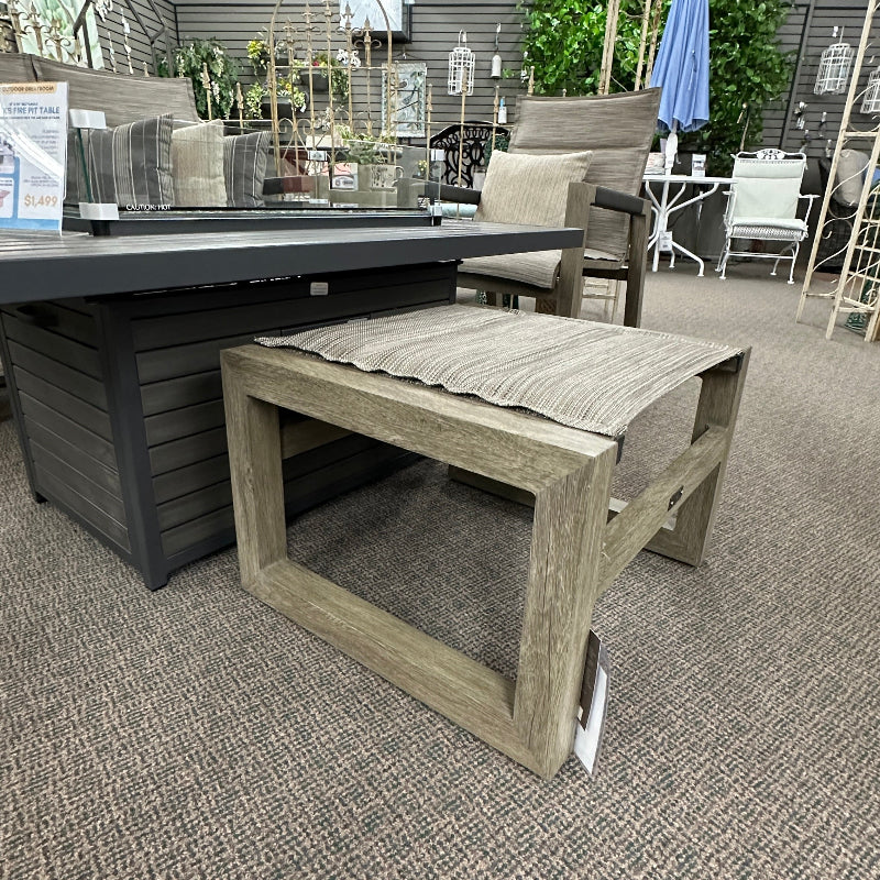 Outdoor furniture set including a table and chairs in an indoor showroom.