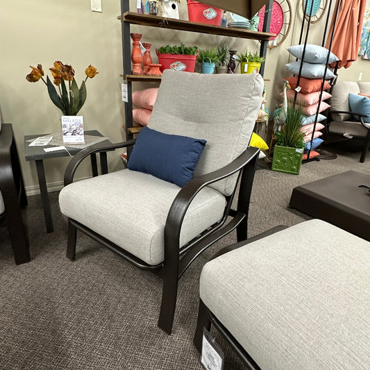 Chair with a blue pillow in an indoor setting with shelves and decor.