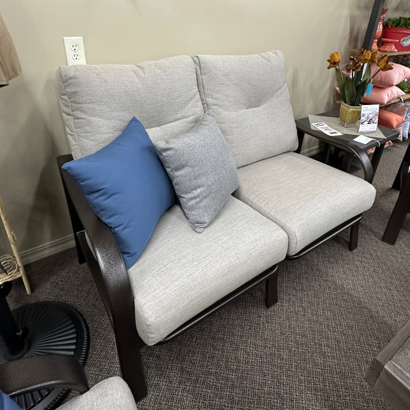 Gray sofa with blue cushions in a room with decorative elements on the wall.