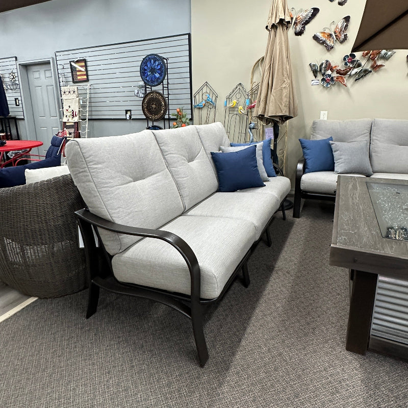 Living room with gray carpet, white sofa, and decorative items on a wall.