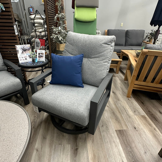 Gray outdoor chair with blue pillow in a furniture store setting