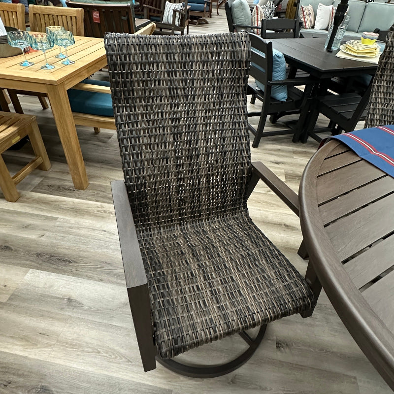 A dark brown outdoor swivel chair with a woven gray and brown textured sling seat and backrest, shown in a furniture showroom on a light wood floor.