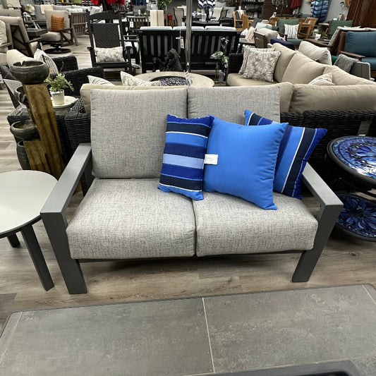 Gray sofa with blue and striped pillows in a furniture store setting