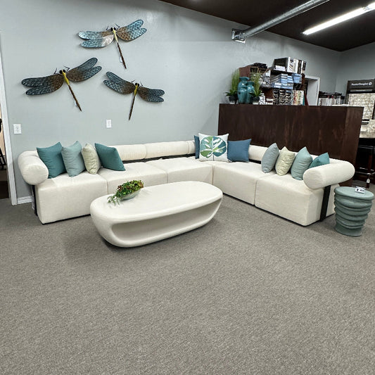 Modern living room with a sectional sofa, coffee table, and decorative elements.