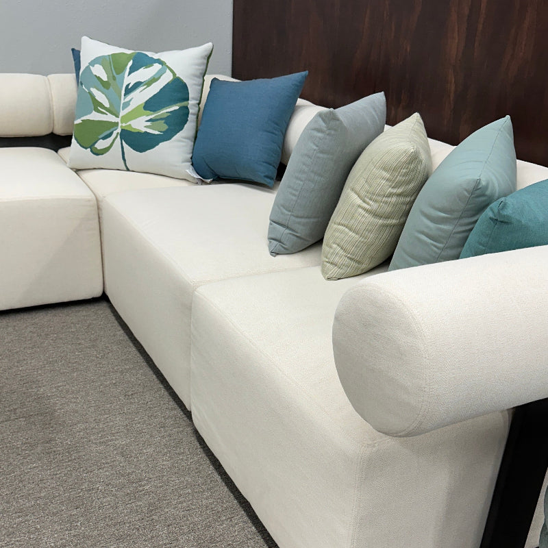 White sectional sofa with colorful pillows on a gray carpet