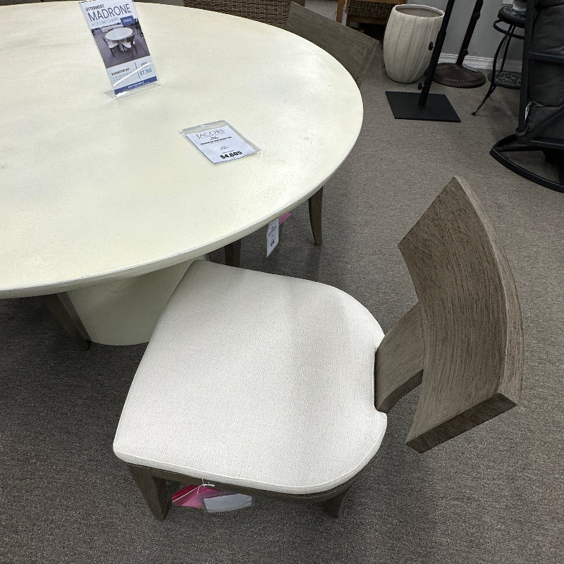 Round white table with a chair in a furniture store setting