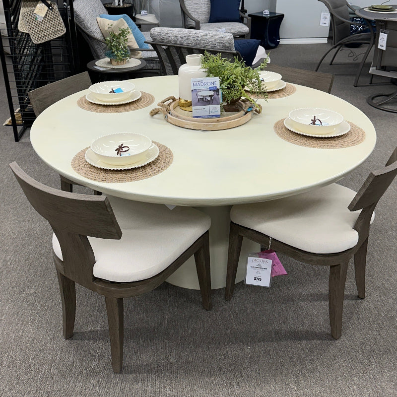 Round dining table with chairs in a showroom setting