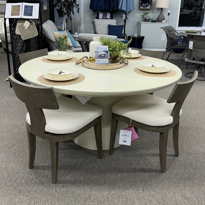 Round dining table with chairs in a showroom setting