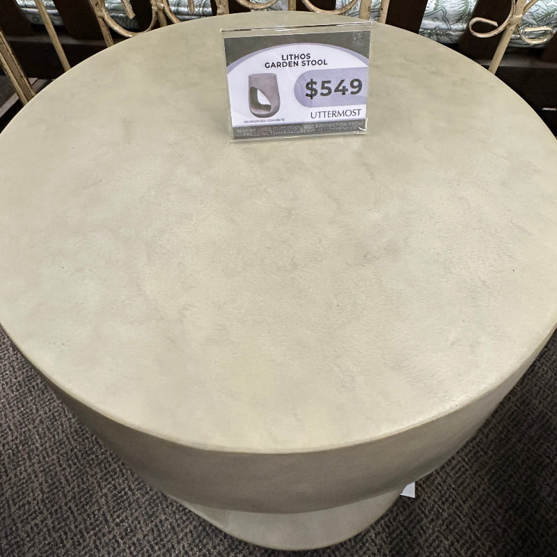 Round stone table with a price tag on a metal stand