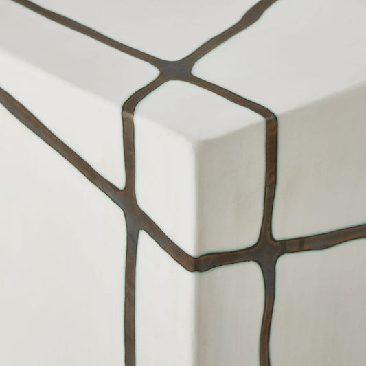 Close-up of a decorative wall mirror with geometric frame on a light background