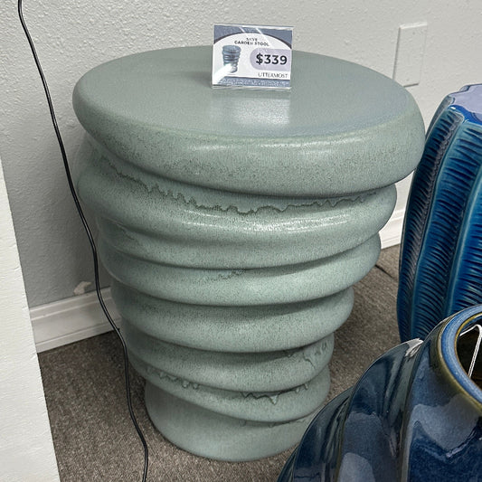 Green textured stool with a price tag in a room setting