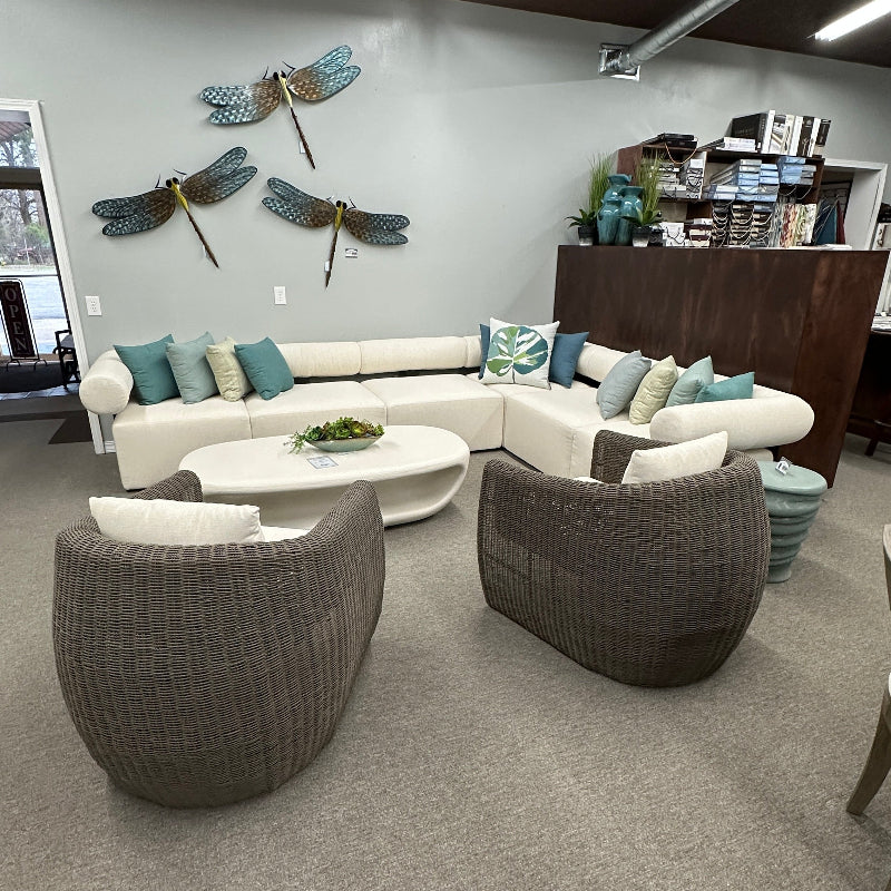 Modern living room with a sectional sofa, armchairs, and decorative elements.