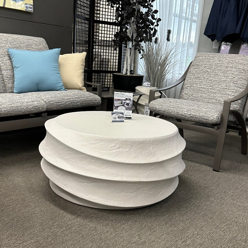 Modern living room with a round white coffee table, gray sofa, and chairs.