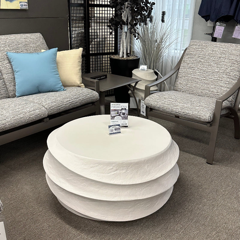 Living room with a white round coffee table, gray sofa, and decorative items.
