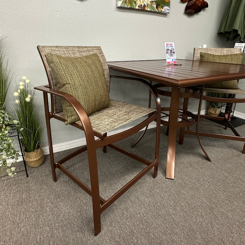 Outdoor patio dining set featuring a square wooden table and two matching armchairs with woven seats, displayed in a showroom setting.