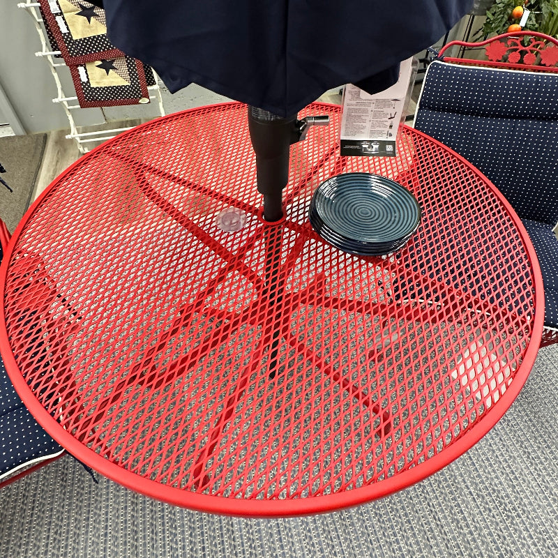 Red mesh table with a black umbrella on a patio