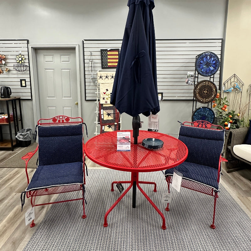 Outdoor furniture set with red table and blue chairs in a showroom.