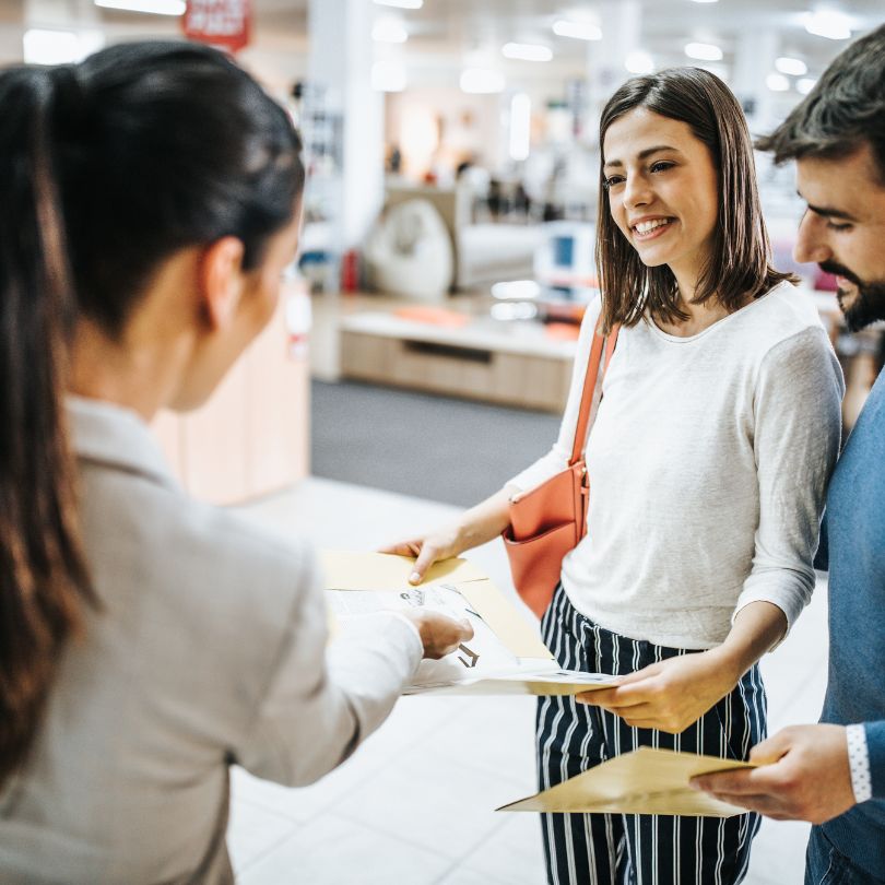 2 women and 1 man looking at fabric samples