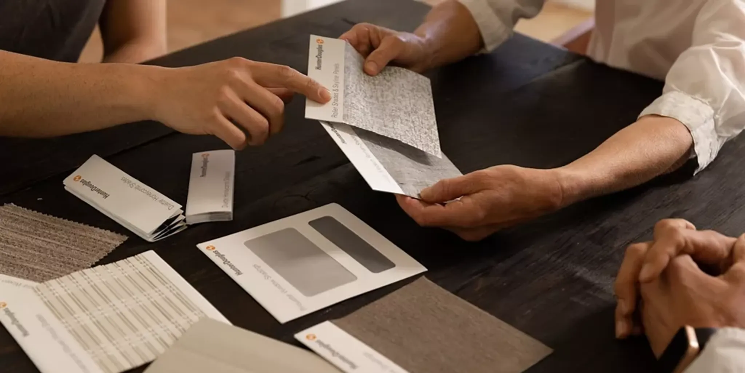 Two people examining material samples on a table